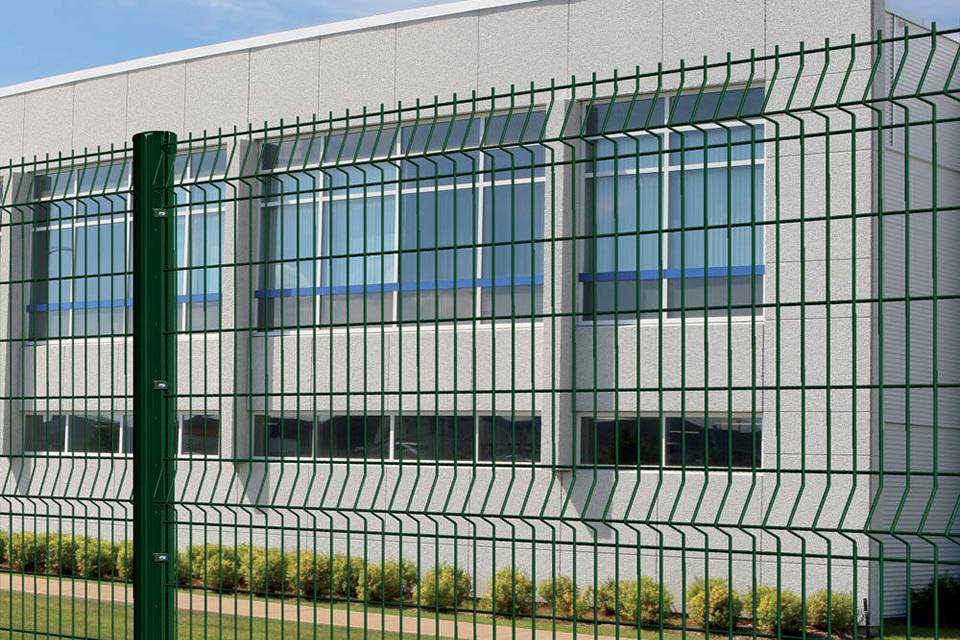 Curvy welded fence is installed along the warehouse.