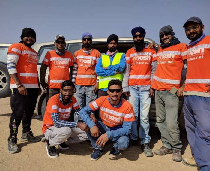 Several workers wearing our company shirt in the chain link fence installation site.